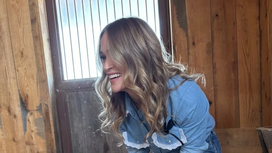 Carrie Underwood feeding a lamb from a bottle.