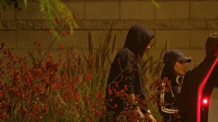 Kim Kardashian and Lewis Hamilton getting out of a car at night.