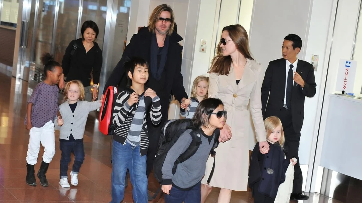 Brad Pitt,. in a black coat and black top, and Angelina Jolie, in a camel colored coat, with their children. From left, Zahara Jolie, in a print top and white jeans, Knox Jolie-Pitt in a grey cardigan, black T-shirt and blue jeans, Maddox Jolie, in a grey striped T-shirt and black and grey striped cardigan and blue jeans, Pax Jolie-Pitt in a grey sweater and blue jeans, Shiloh Jolie, in a grey striped cardigan and Vivienne Jolie in a black  cardigan, black leggings and grey boots.