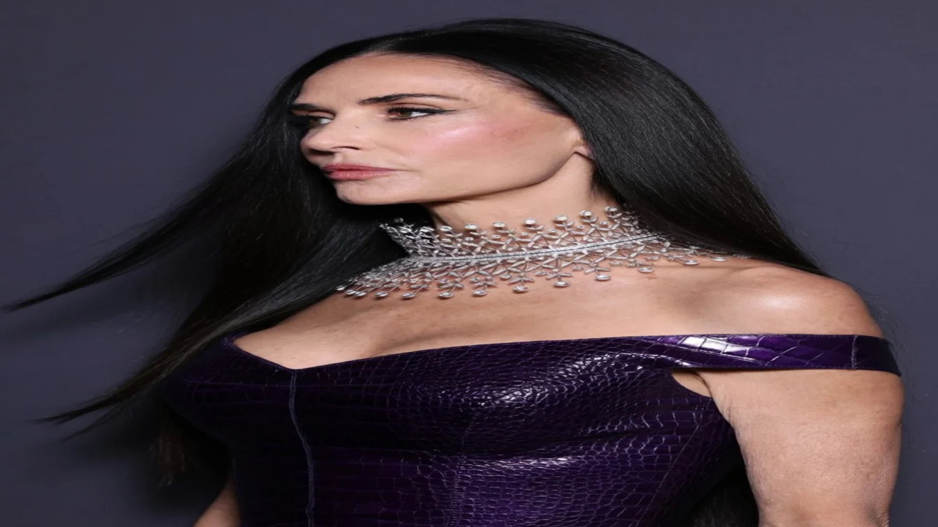 Demi Moore wearing a purple dress and an elaborate diamond necklace.