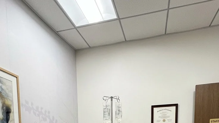 Jessie J with an IV in her arm and wearing a hospital gown, announcing she is cancer-free.