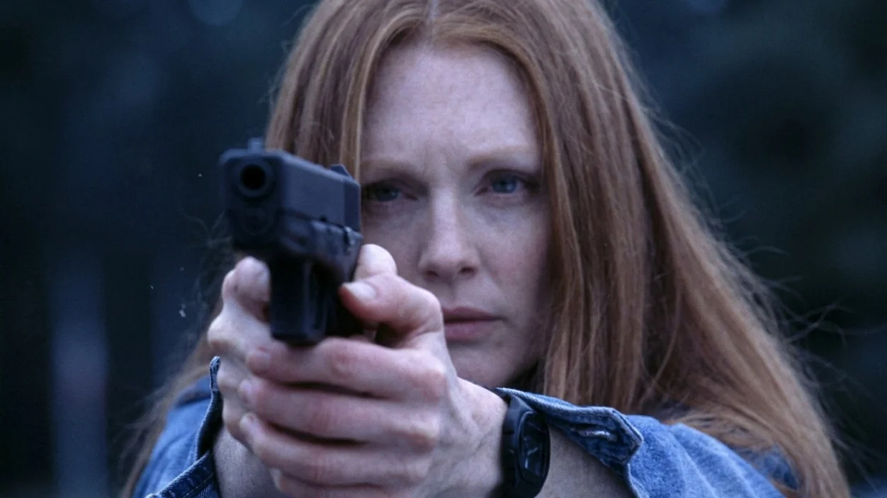 Julianne Moore as Clarice Starling in Hannibal aiming a gun.
