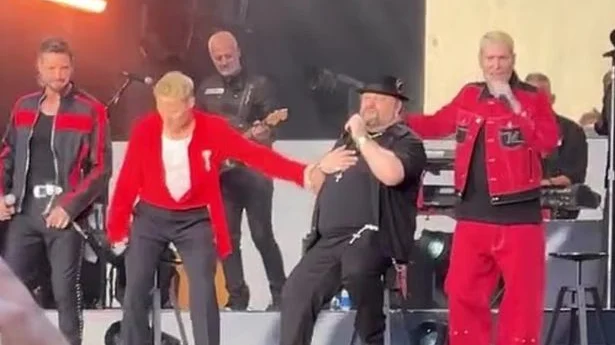 Mikey Graham a cantat pe scaun la reuniunea Boyzone din Londra. Artistul de 53 de ani a rezistat doar patru piese