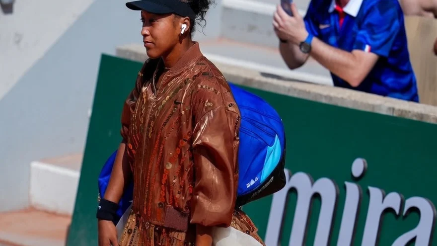 Naomi Osaka arriving courtside in a Nike x Germanier look with flowing white train at Roland-Garros 2026