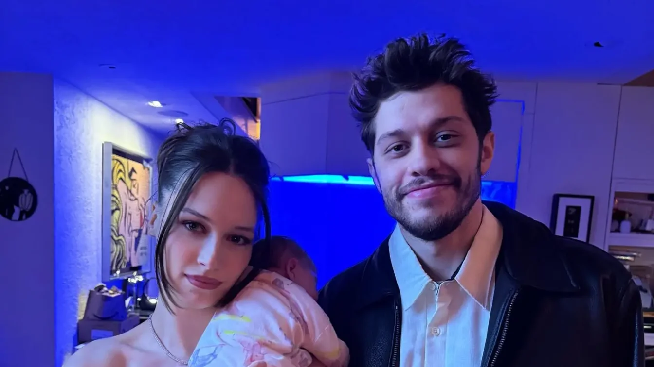 Elsie holding a baby with Pete Davidson standing next to her.