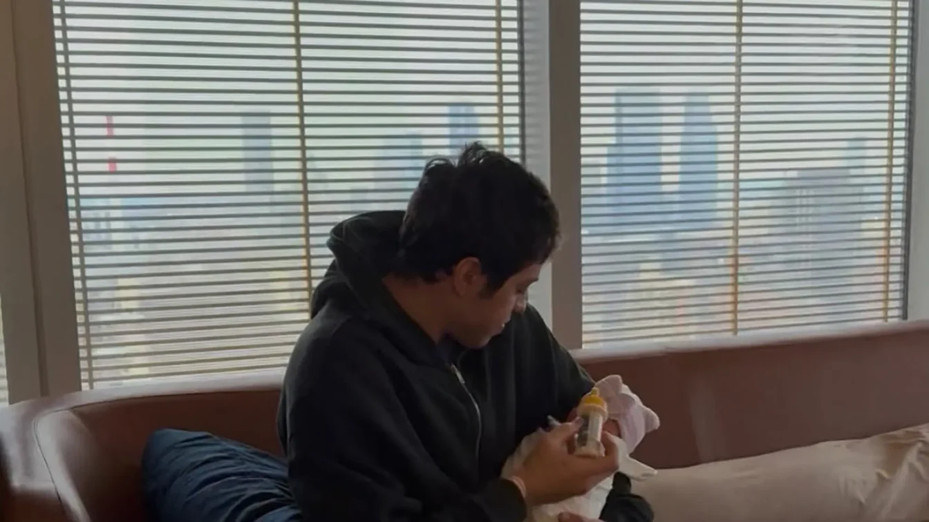 Pete Davidson feeding a baby from a bottle.