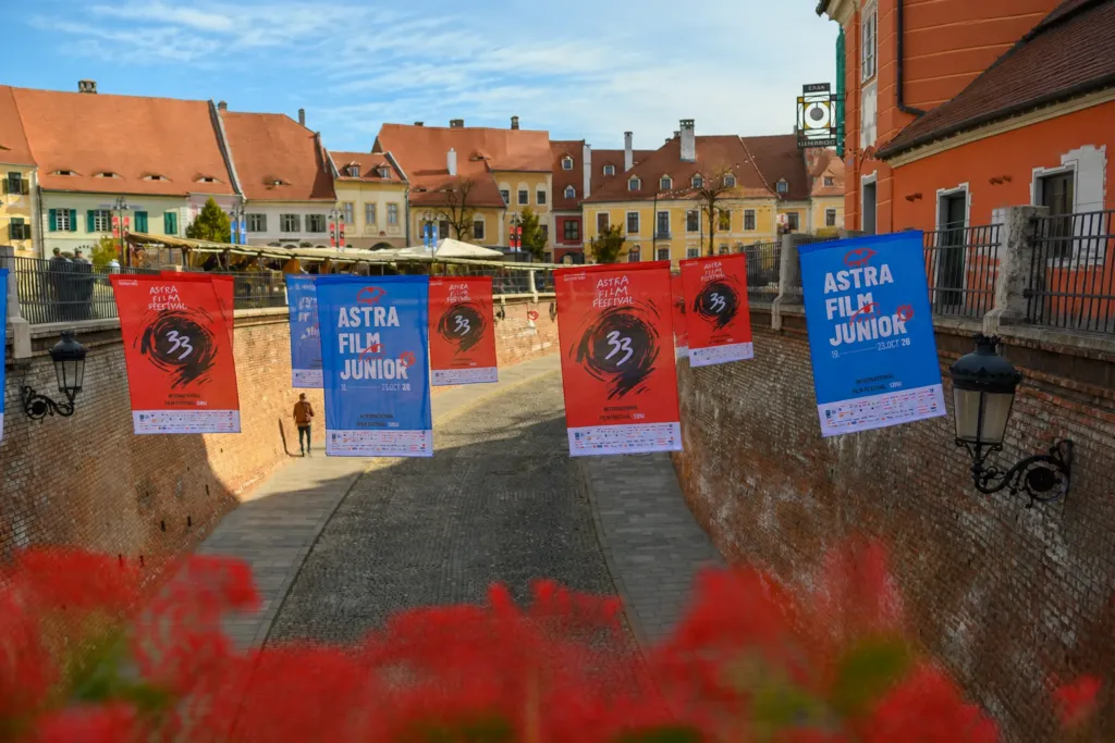 Banners for the Astra Film Festival hanging over a cobblestone street in Sibiu with traditional buildings